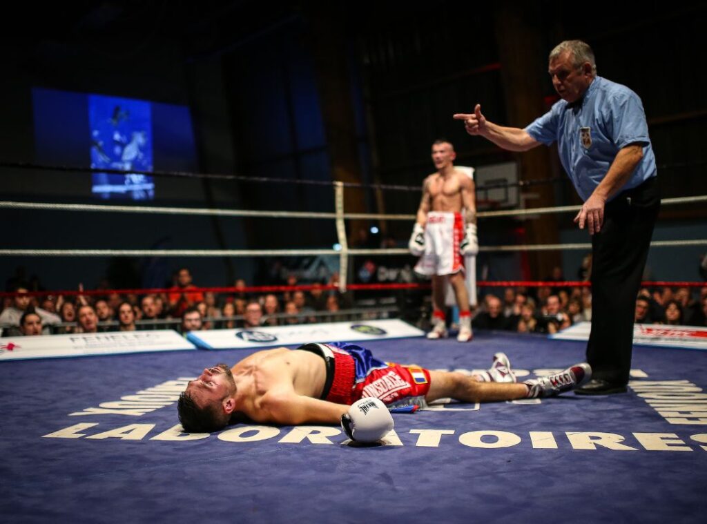 Ringrichter zählt niedergeschlagenen Boxer an.