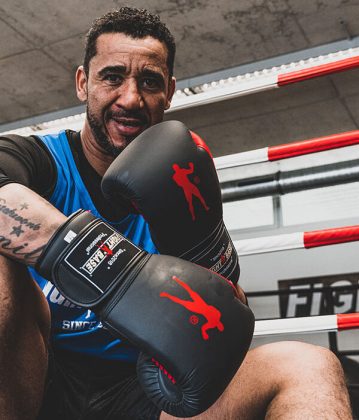 Toby trägt schwarze Boxhandschuhe mit roten Akzenten